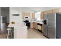 Kitchen features stainless steel appliances and an island with seating at 843 Challenger Ave, Davenport, FL 33897