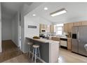 Bright kitchen with light cabinets, stainless steel appliances, and breakfast bar at 843 Challenger Ave, Davenport, FL 33897