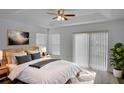 Cozy bedroom featuring a tray ceiling, large windows, and neutral decor at 12755 Oulton Cir, Orlando, FL 32832