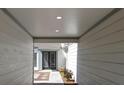 Covered entryway with clean lines, neutral colors, and a tidy walkway to the front door at 203 Red Bud Ln, Longwood, FL 32779