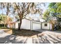 Charming home with a spacious two-car garage and a paver driveway, surrounded by mature trees and beautiful landscaping at 203 Red Bud Ln, Longwood, FL 32779
