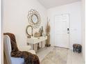 Bright entryway with console table, mirror, and comfy chair at 208 Goldenrod Ln, Kissimmee, FL 34759