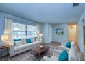 Bright living room with large window, white sofa with accent pillows and wood coffee table on patterned rug at 209 Meadow Hills Dr, Sanford, FL 32773