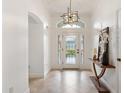 Bright entryway with decorative glass door, modern light fixture, and tiled flooring at 5810 Penney Ln, The Villages, FL 32163