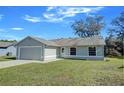 Newly renovated single-story home with gray siding, attached garage, and a well-maintained lawn at 637 Twin Lake Ave, Deltona, FL 32738