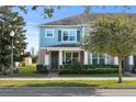 Two-story townhome with light blue exterior, landscaping, and front porch at 15322 Murcott Blossom Blvd, Winter Garden, FL 34787