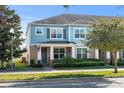 Two-story townhome with light blue exterior, landscaping, and front porch at 15322 Murcott Blossom Blvd, Winter Garden, FL 34787
