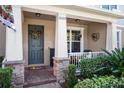 Inviting front porch with stone columns, and a charming wreath at 15322 Murcott Blossom Blvd, Winter Garden, FL 34787