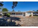 Single story home with a carport and mature trees in the front yard at 1639 Hialeah St, Orlando, FL 32808