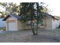 Tan house with orange trim, a one-car garage, and landscaping at 2406 S Lake Avenue Ave, Sanford, FL 32771