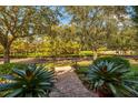Landscaped front yard with mature trees and brick walkway at 4424 New Broad St, Orlando, FL 32814