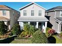 Two-story house with light beige siding, landscaping, and a front porch at 11743 Stein St, Orlando, FL 32832