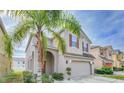 Two-story house with neutral siding, two-car garage, and palm tree at 2746 Stanwood Dr, Kissimmee, FL 34743