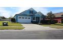 Blue house with white garage door and neatly landscaped front yard at 515 Haywood Ln, Lake Alfred, FL 33850