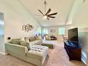 Spacious living room featuring a sectional sofa, large TV, and vaulted ceiling at 5271 Whitstable Way # 1, Orlando, FL 32812