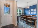 Bright dining room with blue accent wall, wooden table, and six chairs at 8127 Cadman St, Orlando, FL 32832