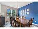 Bright dining room with blue accent wall, wooden table, and six chairs at 8127 Cadman St, Orlando, FL 32832