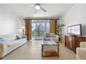 Bright living room with tiled floors, balcony access, and lake views at 13427 Blue Heron Beach Dr # 106, Orlando, FL 32821