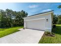 A two car garage with a concrete driveway and manicured front lawn at 14 Guava Terrace Trak, Ocklawaha, FL 32179