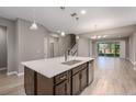Open kitchen with island, dark cabinetry, and stainless steel appliances at 1722 Farmstead Ln, Oviedo, FL 32765
