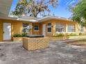 Exterior backyard view featuring a brick grill, white doors and windows, and garden beds at 201 N East St, Leesburg, FL 34748