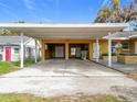 Spacious carport featuring two garage door entrances, suitable for parking and storage at 201 N East St, Leesburg, FL 34748