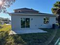View of house back, showcasing a patio and sliding glass doors at 2903 Travelers Palm Dr, Edgewater, FL 32141