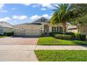 Beautiful house exterior with lush landscaping and a three car garage at 31921 Redtail Reserve Blvd, Sorrento, FL 32776