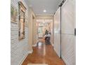 Bright entryway with hardwood floors, white brick wall, and barn door at 31921 Redtail Reserve Blvd, Sorrento, FL 32776