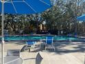 Community pool with lounge chairs and umbrellas at 5259 Images Cir # 102, Kissimmee, FL 34746