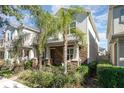 Two-story house with stone and light-colored siding, palm trees, and well-manicured lawn at 5539 Bowman Dr, Winter Garden, FL 34787