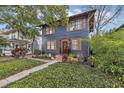 Charming two-story home with a well-manicured lawn, wood shutters, and a welcoming red front door at 606 E Amelia St, Orlando, FL 32803
