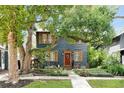 Charming home featuring a landscaped front yard, mature tree, and inviting red front door at 606 E Amelia St, Orlando, FL 32803