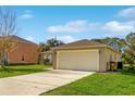 Single car garage with a beige exterior and a spacious driveway at 849 Jarnac Dr, Kissimmee, FL 34759