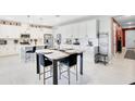 Modern kitchen with white cabinetry, stainless steel appliances, and a dining area at 10249 Spring Lake Dr, Clermont, FL 34711