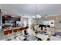 Open kitchen features granite countertops, stainless steel appliances, and an island with seating at 1582 Moon Valley Dr, Champions Gate, FL 33896