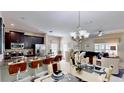 Open concept kitchen and dining area with granite counters and modern lighting at 1582 Moon Valley Dr, Champions Gate, FL 33896