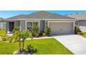 Single-story house with gray siding, two-car garage, and landscaping at 4505 Hummingbird Ln, Haines City, FL 33844