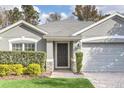 Gray house with a two-car garage and lush landscaping at 5813 Great Egret Dr, Sanford, FL 32773