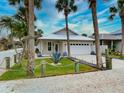 A charming one-story home with a white garage door and a landscaped front yard at 821 E 1St Ave, New Smyrna Beach, FL 32169