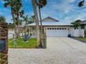 A beach-style home with a white garage door, palm trees, and a gravel driveway at 821 E 1St Ave, New Smyrna Beach, FL 32169