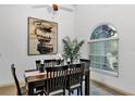 Cozy dining room featuring a wood table set, modern art, and natural light from the window at 2376 Park Village Pl, Apopka, FL 32712