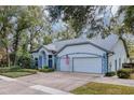 House exterior showcasing a two-car garage and manicured lawn at 2376 Park Village Pl, Apopka, FL 32712