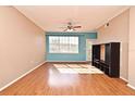 Living room with hardwood floors and a large window at 2572 Robert Trent Jones Dr # 1231, Orlando, FL 32835