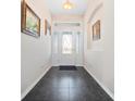 Elegant foyer featuring dark tile flooring and a front door with decorative glass at 26812 Augusta Springs Cir, Leesburg, FL 34748