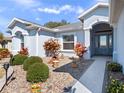 Inviting front entrance featuring decorative landscaping, a walkway, and glass door at 26812 Augusta Springs Cir, Leesburg, FL 34748