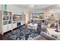 Bright living room with a comfortable gray sectional, ceiling fan, and large windows at 26812 Augusta Springs Cir, Leesburg, FL 34748