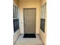 Front entry with brown door and small welcome mat at 3017 Cottage Grove Ct # Ge, Orlando, FL 32822