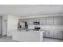 Modern kitchen with stainless steel appliances and grey cabinets at 307 River Front Way, Edgewater, FL 32141