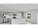 Bright kitchen featuring stainless steel appliances, center island, and shaker style cabinets at 307 River Front Way, Edgewater, FL 32141